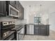 Sleek kitchen with black countertops, stainless steel appliances, and stylish pendant lighting at 6454 Baytown Dr, Sarasota, FL 34240