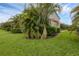 Well-manicured lawn features tropical landscaping and lush green hedges around the property at 6454 Baytown Dr, Sarasota, FL 34240