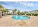 Community pool surrounded by lounge chairs and palm trees under a partly cloudy sky at 6454 Baytown Dr, Sarasota, FL 34240