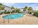 Community pool surrounded by lounge chairs, palm trees, and manicured landscaping at 6454 Baytown Dr, Sarasota, FL 34240