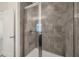 Shower featuring gray tile surround, glass door, and light fixture at 6454 Baytown Dr, Sarasota, FL 34240
