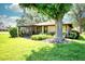 Spacious backyard with a large tree, lush lawn, a screened-in patio, and mature landscaping at 6504 Heritage Ln # 99, Bradenton, FL 34209