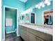 Double sink bathroom with granite countertop, stylish lighting, and gray cabinetry at 6604 7Th Avenue W Cir, Bradenton, FL 34209