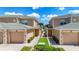 Exterior view of two townhomes with garages, shared walkway, and well-maintained landscaping on a sunny day at 6604 7Th Avenue W Cir, Bradenton, FL 34209