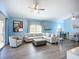 Spacious living room with a ceiling fan, hardwood floors, and large windows providing plenty of natural light at 6604 7Th Avenue W Cir, Bradenton, FL 34209