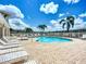 Community pool with many lounge chairs surrounding the perimeter and clear blue skies at 6604 7Th Avenue W Cir, Bradenton, FL 34209