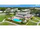 Aerial view of community pool and clubhouse surrounded by lush gardens and bright green lawn at 6604 7Th Avenue W Cir, Bradenton, FL 34209