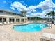 Bright outdoor pool with many lounge chairs and tables under a partly cloudy, bright blue sky at 6604 7Th Avenue W Cir, Bradenton, FL 34209