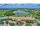 Aerial view of a golf community with a clubhouse, lush greenery, and beautiful lake views at 6918 Grand Estuary Trl # 104, Bradenton, FL 34212