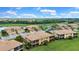 Residential community with multiple homes, pond, and golf course in the distance at 6918 Grand Estuary Trl # 104, Bradenton, FL 34212