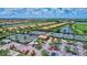 Overhead shot of community tennis courts surrounded by lush landscaping, parking, and residential homes near waterways at 6918 Grand Estuary Trl # 104, Bradenton, FL 34212