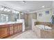 Primary bathroom featuring double vanity, glass-enclosed shower, and a luxurious soaking tub at 6918 Grand Estuary Trl # 104, Bradenton, FL 34212