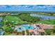 Stunning aerial view of the community pool, clubhouse, and golf course with water feature at 6918 Grand Estuary Trl # 104, Bradenton, FL 34212