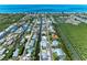 Scenic aerial view of a waterfront community with canal access and stunning ocean views in the distance at 726 Jungle Queen Way, Longboat Key, FL 34228