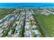 Beautiful aerial view of a waterfront community with canal access and stunning ocean views in the distance at 726 Jungle Queen Way, Longboat Key, FL 34228