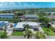Stunning aerial view of waterfront home with pool and canal access in a lush, tropical neighborhood with ocean views at 726 Jungle Queen Way, Longboat Key, FL 34228