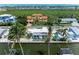 Aerial view of a canal-front house featuring a pool, lush greenery, palm trees, and boat dock with waterway access at 726 Jungle Queen Way, Longboat Key, FL 34228