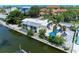Aerial view of waterfront home with a pool, canal access, and lush tropical landscaping with seating around the pool at 726 Jungle Queen Way, Longboat Key, FL 34228