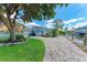 Paver patio leads to a private dock and waterway access, surrounded by lush landscaping, perfect for waterfront living at 726 Jungle Queen Way, Longboat Key, FL 34228