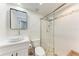 Well-lit bathroom with a modern vanity, tiled shower, and glass door at 726 Jungle Queen Way, Longboat Key, FL 34228