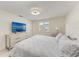 Comfortable bedroom with a ceiling fan, dresser with TV, and white walls at 726 Jungle Queen Way, Longboat Key, FL 34228
