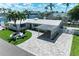 Charming waterfront home featuring lush landscaping, a covered carport, and a well-manicured lawn at 726 Jungle Queen Way, Longboat Key, FL 34228