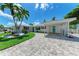 Charming exterior view of this waterfront property featuring lush landscaping, a manicured lawn, and covered carport at 726 Jungle Queen Way, Longboat Key, FL 34228