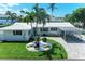 Charming single-story home with well-manicured lawn, lovely landscaping, a carport, and a paver driveway at 726 Jungle Queen Way, Longboat Key, FL 34228