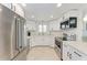 Modern kitchen with stainless steel appliances, granite countertops, and white cabinetry offers style and functionality at 726 Jungle Queen Way, Longboat Key, FL 34228