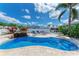 Inviting pool area with lounge chairs, lush landscaping, and a fence for privacy at 726 Jungle Queen Way, Longboat Key, FL 34228