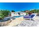 Charming backyard pool with a sun-soaked patio, fire pit, mature palm trees, and lounge chairs at 726 Jungle Queen Way, Longboat Key, FL 34228