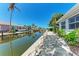 Waterfront view of the neighborhood canal, a stone walkway, and mature landscaping at 726 Jungle Queen Way, Longboat Key, FL 34228