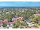 Expansive aerial view of community with mature trees, serene pond, and well-maintained red tile roofs at 7674 Fairway Woods Dr # 1605, Sarasota, FL 34238