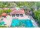 Aerial view of community pool and clubhouse surrounded by lush tropical landscaping at 7674 Fairway Woods Dr # 1605, Sarasota, FL 34238