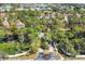 Aerial perspective of the community entrance featuring lush landscaping and mature trees at 7674 Fairway Woods Dr # 1605, Sarasota, FL 34238
