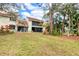 A view of backyard with a screened in porch and a lush green lawn at 7674 Fairway Woods Dr # 1605, Sarasota, FL 34238