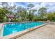 Inviting community pool with clear blue water, surrounded by lounge chairs and lush landscaping at 7674 Fairway Woods Dr # 1605, Sarasota, FL 34238