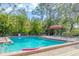 Community pool surrounded by lush trees and ample space for residents to relax at 7674 Fairway Woods Dr # 1605, Sarasota, FL 34238