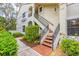 A condo exterior with red-tiled stairs, landscaped grounds, and neutral stucco at 7674 Fairway Woods Dr # 1605, Sarasota, FL 34238