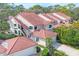 Exterior of a condominium featuring a tile roof, attached garage, and verdant landscaping at 7674 Fairway Woods Dr # 1605, Sarasota, FL 34238