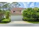 Charming home exterior featuring a two-car garage, well-manicured landscaping, and a classic tile roof at 7674 Fairway Woods Dr # 1605, Sarasota, FL 34238