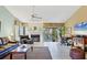 Bright living room with fireplace, tile floor, comfortable leather seating, and views of outdoor greenery at 7674 Fairway Woods Dr # 1605, Sarasota, FL 34238