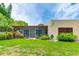 A serene backyard featuring a screened-in lanai, mature trees, and a well-manicured lawn at 814 Spring Lakes Blvd # 14, Bradenton, FL 34210