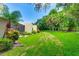 Lush backyard with mature trees, colorful plants, and a screened-in lanai at 814 Spring Lakes Blvd # 14, Bradenton, FL 34210