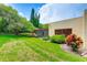 Lush backyard featuring a screened-in lanai, tropical landscaping, and well-maintained lawn at 814 Spring Lakes Blvd # 14, Bradenton, FL 34210