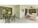 Bright lanai with tile floors, dining area, sitting area, and large sliding glass doors overlooking lush greenery at 814 Spring Lakes Blvd # 14, Bradenton, FL 34210