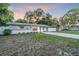 Charming single-story home with a gravel driveway, a green lawn, and fenced yard at 946 Charlotte Ave, Sarasota, FL 34237