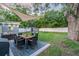 Exterior view of the backyard featuring a dining area, grill, green lawn, and storage shed at 946 Charlotte Ave, Sarasota, FL 34237
