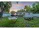 Wide backyard view showcasing a lawn, dining set, lounge area, and hammock at 946 Charlotte Ave, Sarasota, FL 34237
