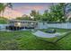Expansive backyard with green grass, dining and lounge furniture, and privacy fencing at 946 Charlotte Ave, Sarasota, FL 34237
